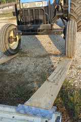 Diamond Plate aluminum loading ramp kit being used on the back of a truck, loading a tractor